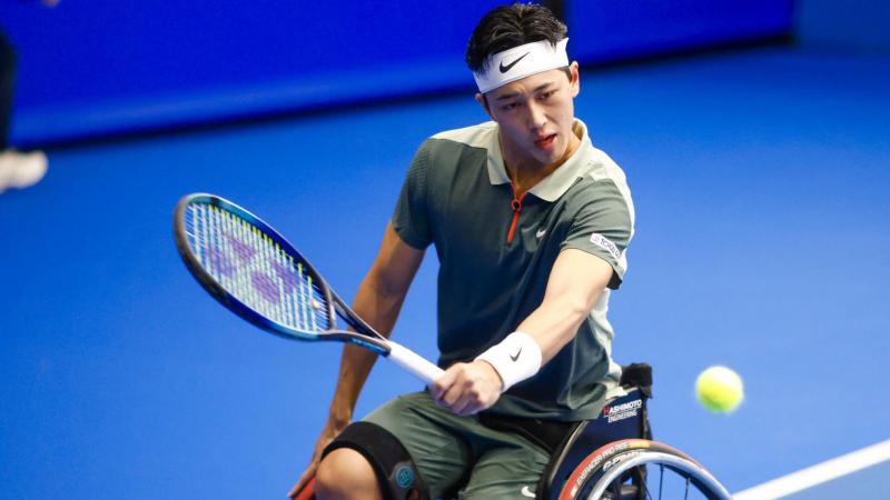 Wheelchair tennis player Tokito Oda plays a backhand