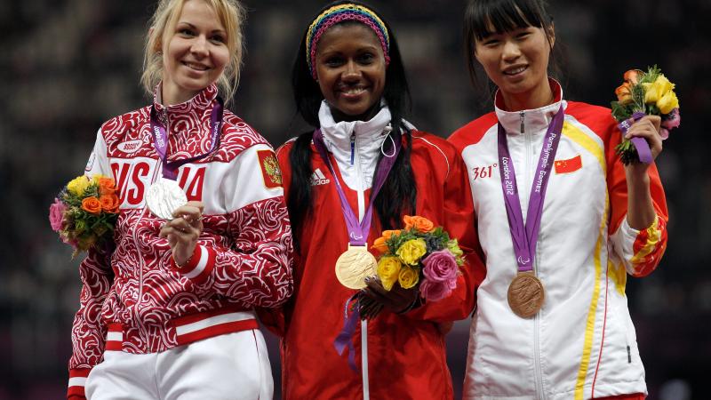 A picture of women on a podium with medals around their neck