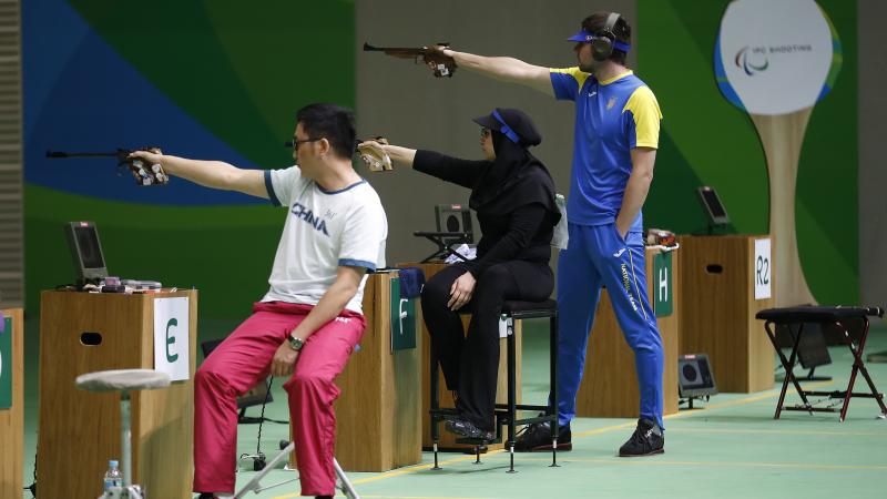 P4 - Mixed 50m Pistol SH1 - Shooting - Rio 2016 Two sitting and one standing shooting para athlete aiming at the targets