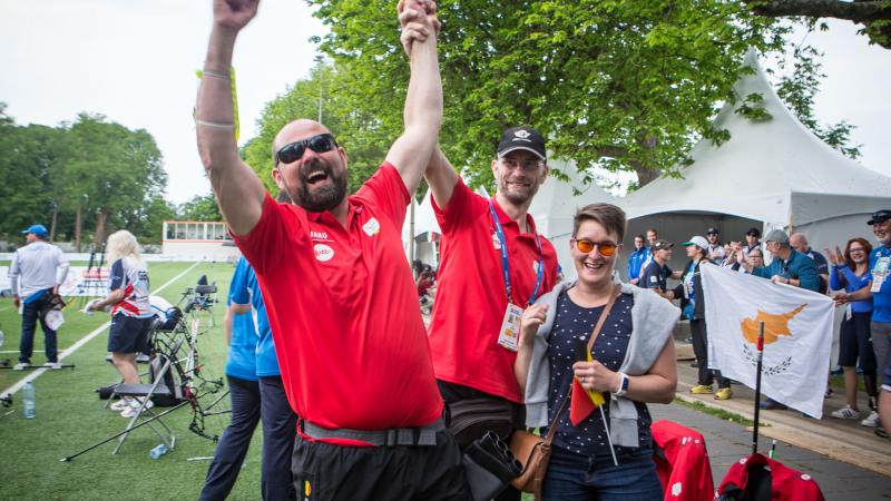 Vision impaired male archer celebrates with his coach hugging him