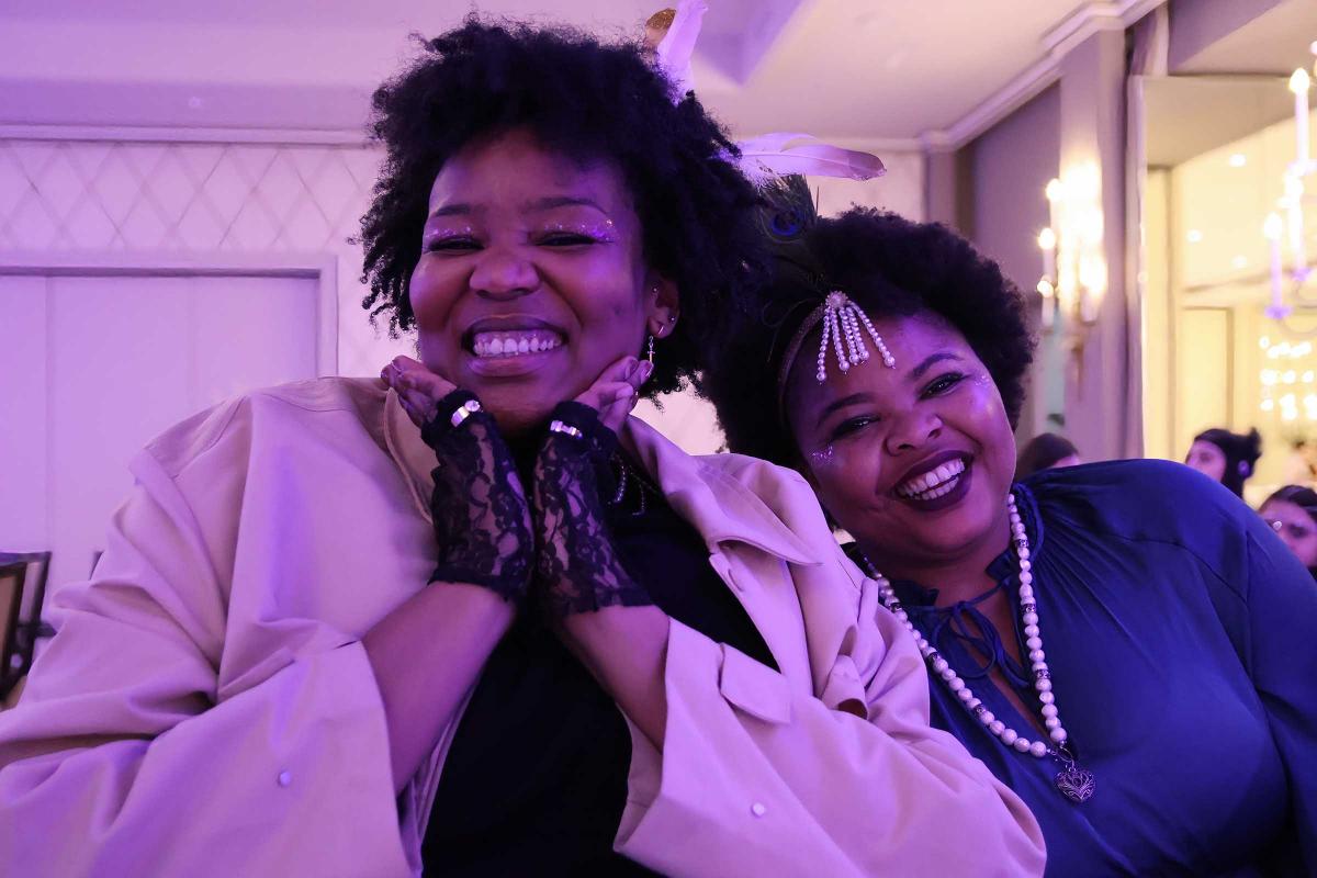 Two IPC staff smile and pose for a photo during the IPC winter party in 2024