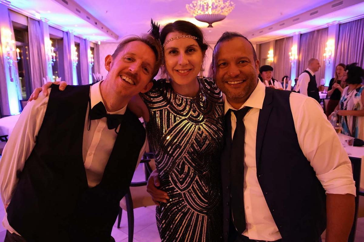 Three IPC staff smile and pose for a photo during the IPC winter party in 2024