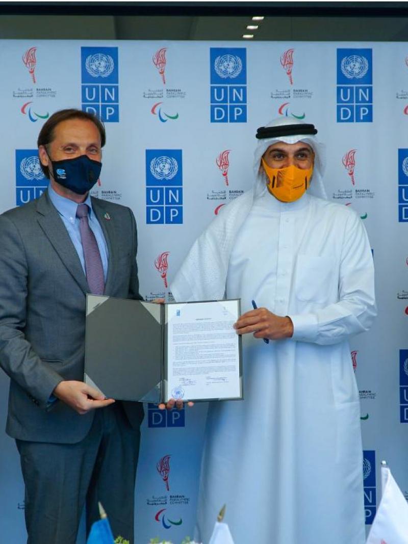 Group of men posing for photo holding  signed agreement