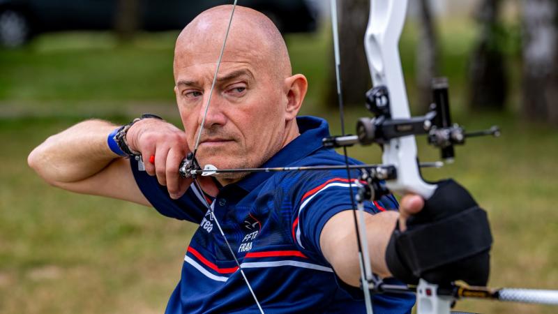 French Para archer Damien Letulle is preparing to shoot an arrow during competition. 