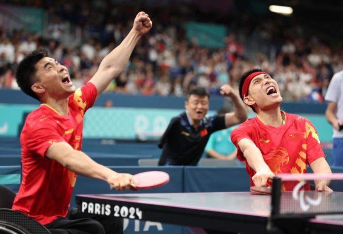 Two male athletes pump their fists to celebrate