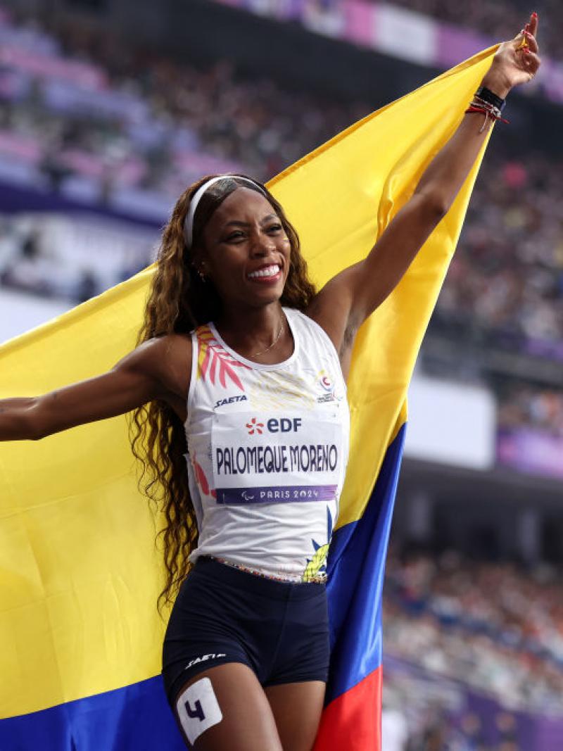 A female athlete with the Colombian flag in a stadium