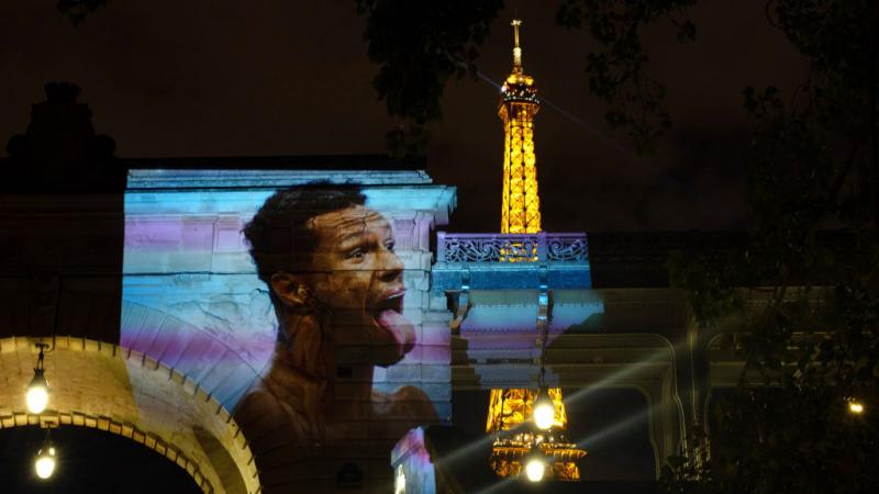 A projection of Brazilian swimmer Gabriel Araujo near the Eiffel Tower