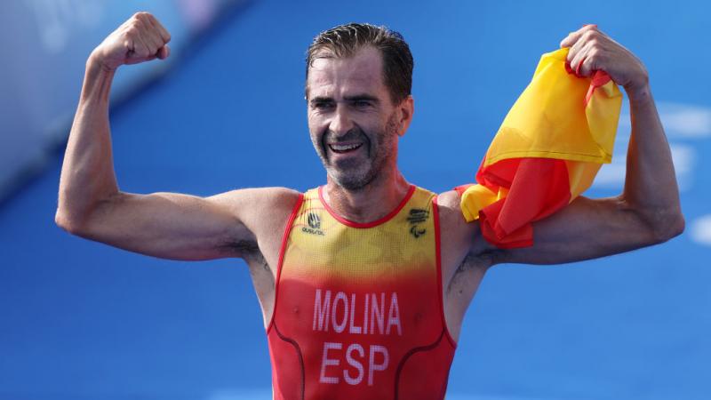 Para triathlete Daniel Molina shows off his biceps at the finish line 