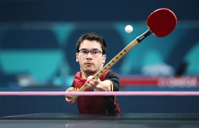 Ian Seidenfeld of Team United States returns a table tennis ball with a paddle that is attached to a stick