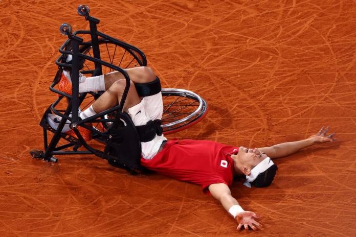 Wheelchair tennis player Tokito Oda lies on the court in celebration