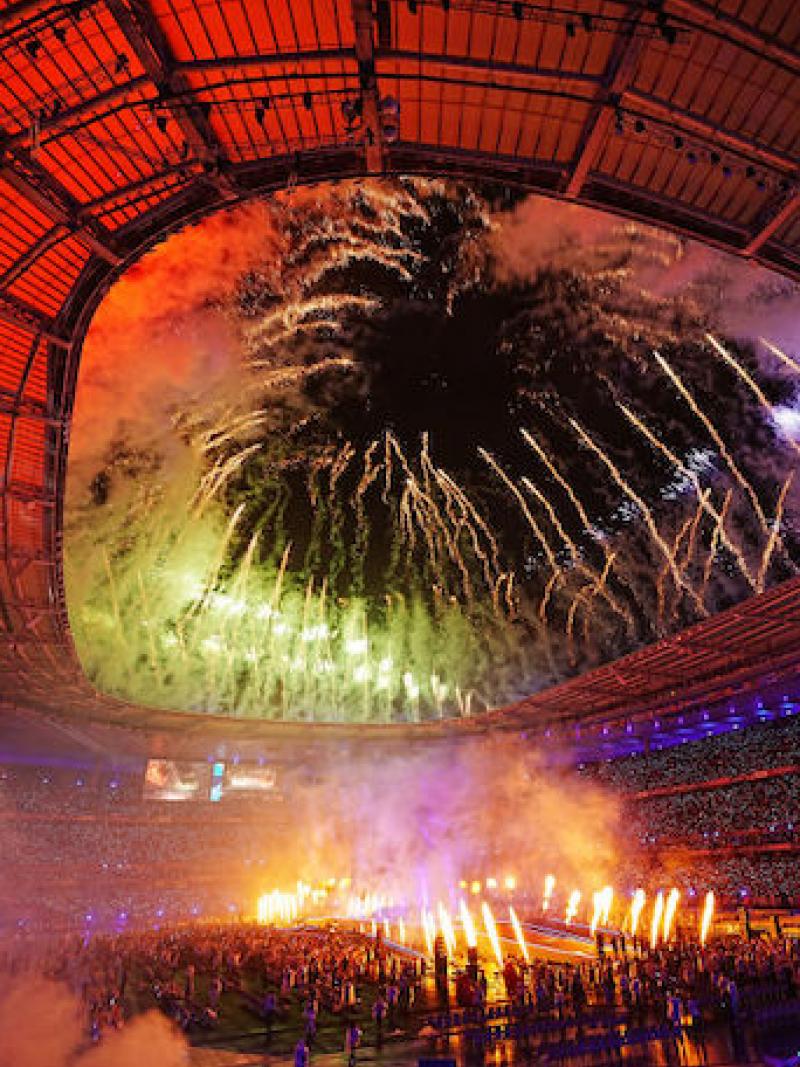 Fireworks slight up the centre and roof of a large stadium