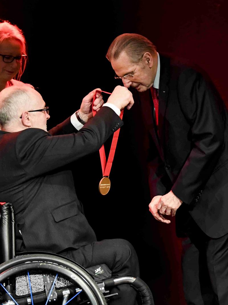 Man puts on medal of honor on another man