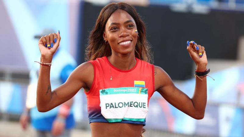 A female athlete from Colombia celebrates after a win by pumping her fists