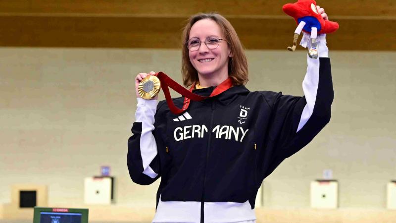 A shooter celebrates her medal