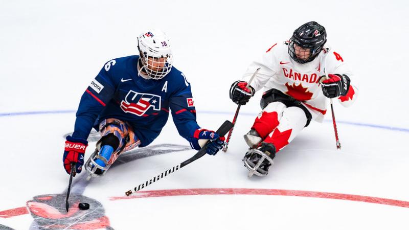 Two Para ice hockey players from USA and Canada in a game