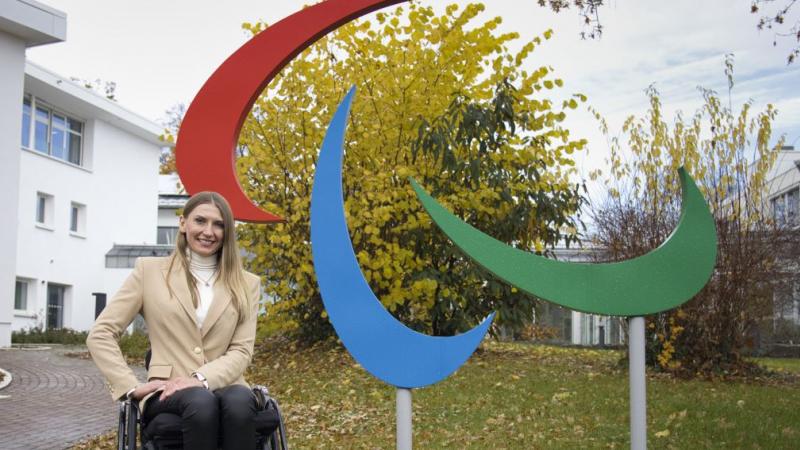 Vladyslava Kravchenko poses for a photograph next to the Paralympic symbol in front of the IPC headquarters in Bonn, Germany